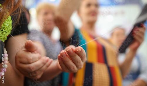 People hold silk fibers in a factory. © schankz