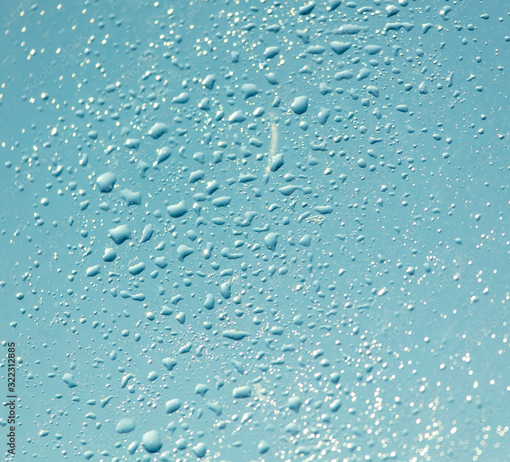 Drops of water on a blue glass window Drops of water on a blue glass window