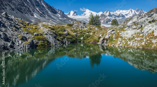 Picturesque mountain lake on a sunny day. Beautiful reflection, panoramic view. Summer rest.