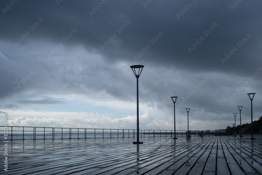 Lanterns on the embankment after rain and cloudy sky