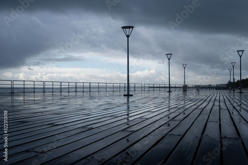 Lanterns on the embankment after rain and cloudy sky