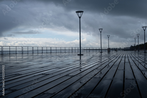 Lanterns on the embankment after rain and cloudy sky