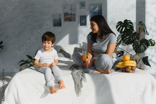 Closeup of happy family playing over the bed in a relaxed morning. Weekend family leisure time concept. © Serhii