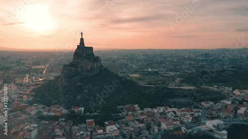 Aerial footage circling the Sacred heart statue of Jesus on top of Monteagudo castle near Murcia Spain during sunset photo