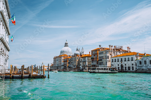 Venice, Italy. Beautiful view of turquoise-green colored Grand Canal and Basilica Santa Maria della Salute against blue sky © Igor Tichonow