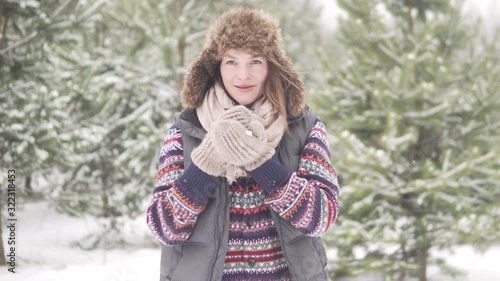 A woman drinks hot tea in winter in a beautiful snowy forest photo