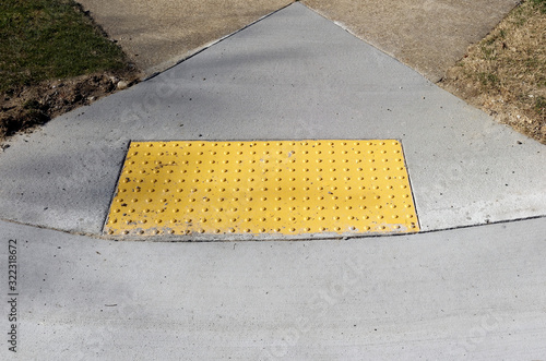 Sidewalk curb ramp with bumpy anti slip pad.