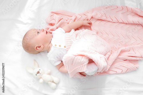 Portrait of cute little baby lying on bed