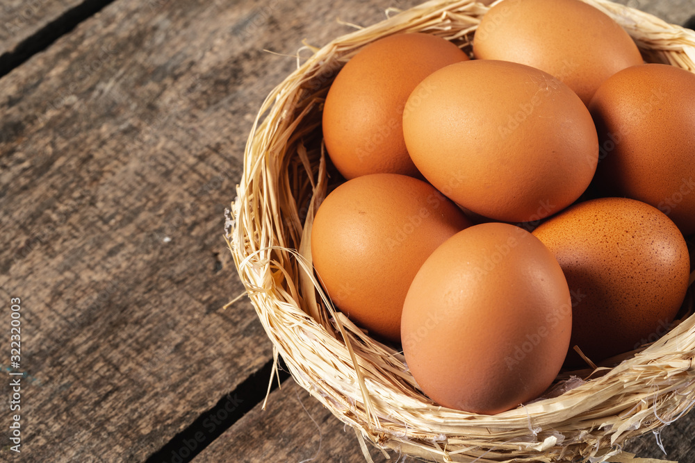 eggs in the hay nest on wooden table eggs in the hay nest on wooden table