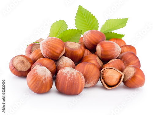 Hazelnuts with green leaves isolated on white background
