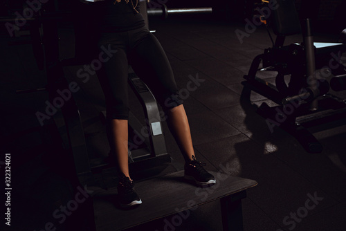 cropped view of african american girl working out on gym machine