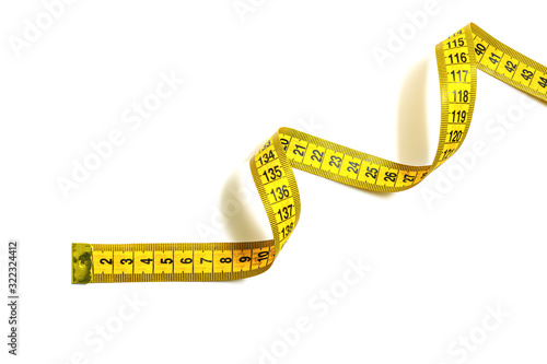 Yellow measuring tape curls on a white background isolated. Tailor's sewing cloth measuring tool. Ruler for body measuring. © Andrii A