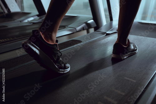 Cropped view of african american woman legs wearing sneakers on treadmill in gym © LIGHTFIELD STUDIOS