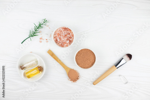 Homemade spa cosmetic set with salt and oil on white wooden background. Copy space. Flat lay style.