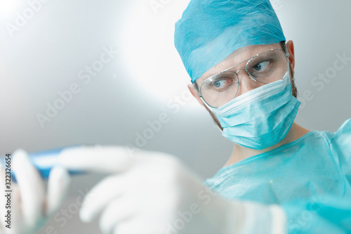 assistant passes the instrument to the surgeon in the operating room
