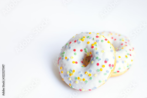 two glazed donut with colored sprinkles on white background