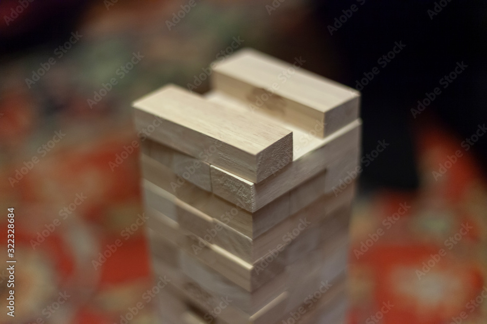 Tower of wooden blocks. Who will win and not drop more than one detail. A game for a fun company. The development of accuracy and fine motor skills. Wooden set of identical boards. Tower of wooden blocks. Who will win and not drop more than one detail. A game for a fun company. The development of accuracy and fine motor skills. Wooden set of identical boards.