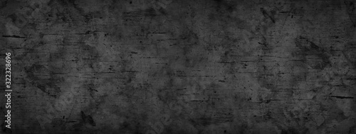 Black grunge background. Dark gray rough dirty surface texture. Close-up. Distressed backdrop. Black abstract wide grunge banner with copy space for your design.