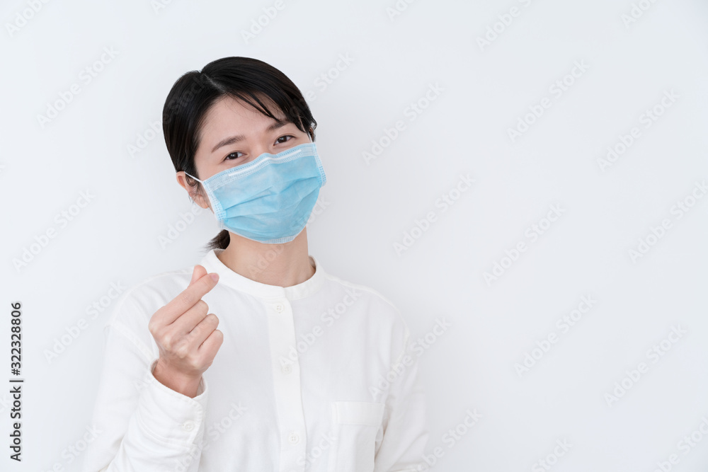 Asian woman wearing a protective mask and showing heart gesture Asian woman wearing a protective mask and showing heart gesture