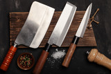 Chopping knives and spices on a dark table