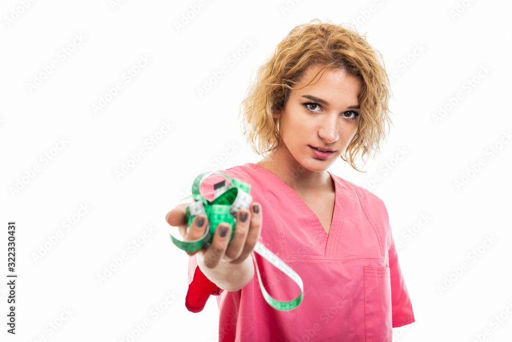 Selective focus of nurse wearing pink scrub holding measure tape Selective focus of nurse wearing pink scrub holding measure tape