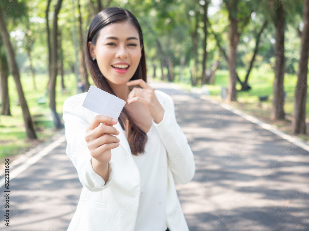 asia happy business woman holding blank card stand in park asia happy business woman holding blank card stand in park