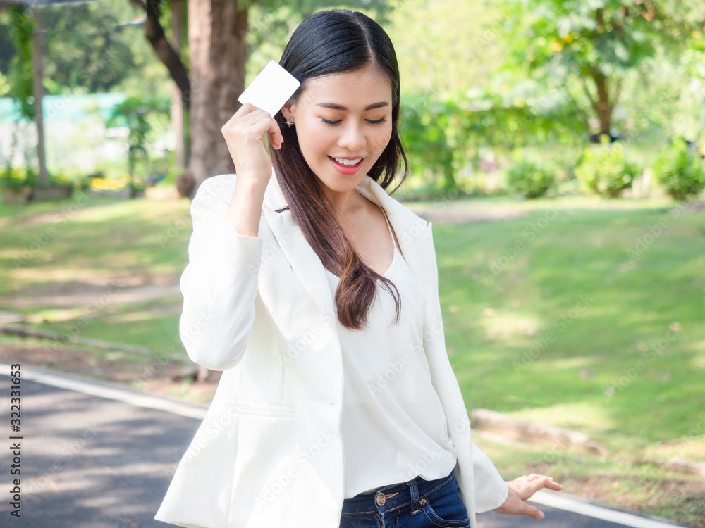 asia happy business woman holding blank card stand in park asia happy business woman holding blank card stand in park