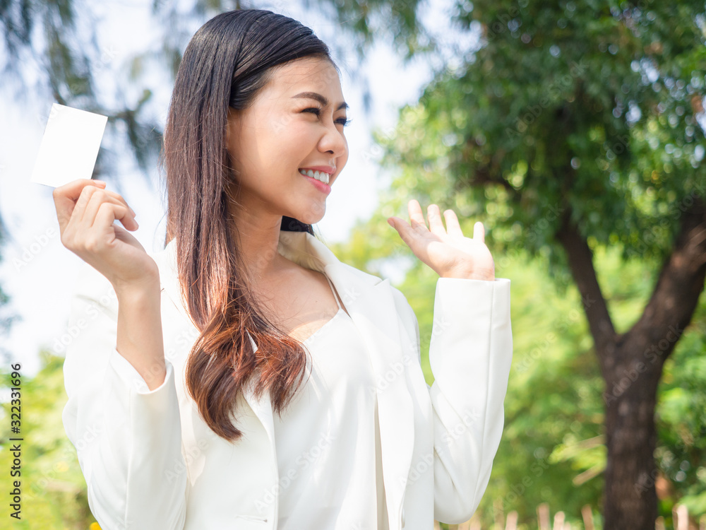 asia happy business woman holding blank card stand in park asia happy business woman holding blank card stand in park