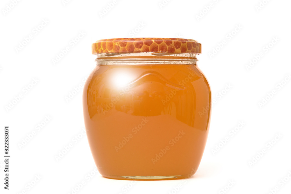 Glass jar with fresh bright honey on a white wall background. The concept of healthy eating and healthy foods. Glass jar with fresh bright honey on a white wall background. The concept of healthy eating and healthy foods.