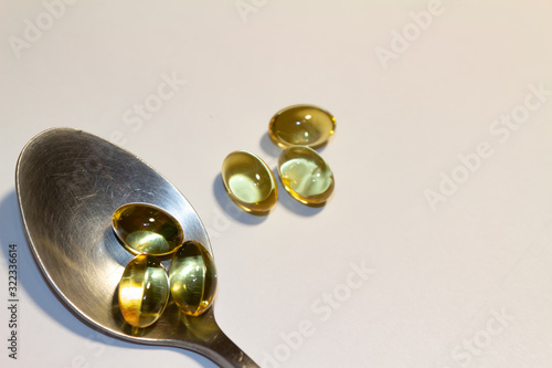 capsules of fish oil lie on a hand on a light background. view from above. vitamins for health.