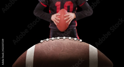American football ball and player on dark background
