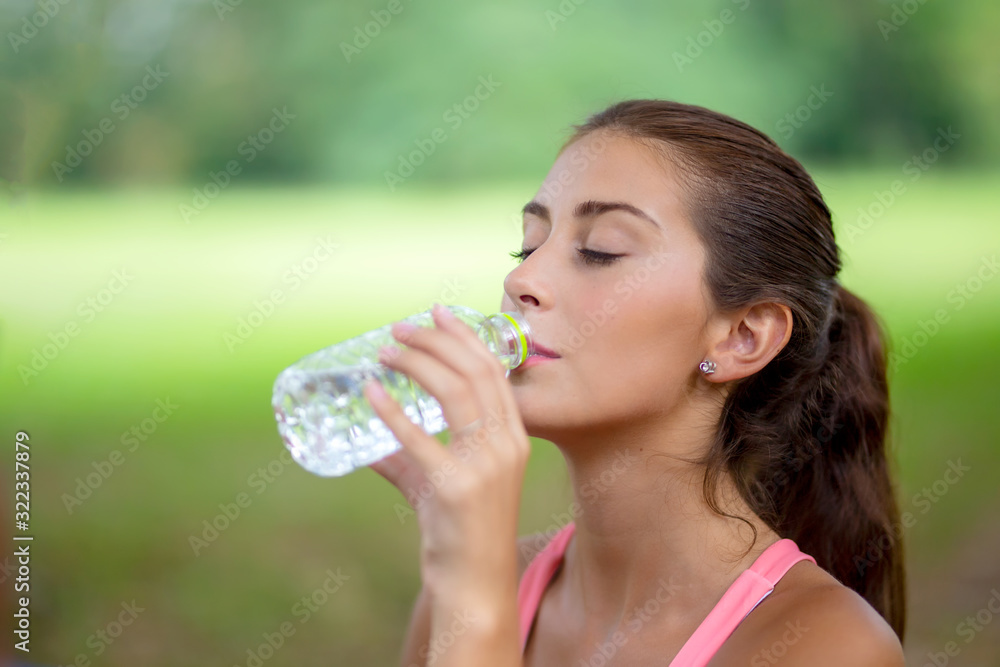 young woman drinking water from a bottle young woman drinking water from a bottle