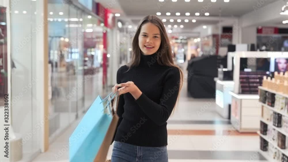girl goes with packages after shopping in mall girl goes with packages after shopping in mall