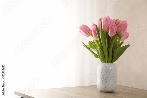 Tulips in vase on wooden background, space for text © Atlas