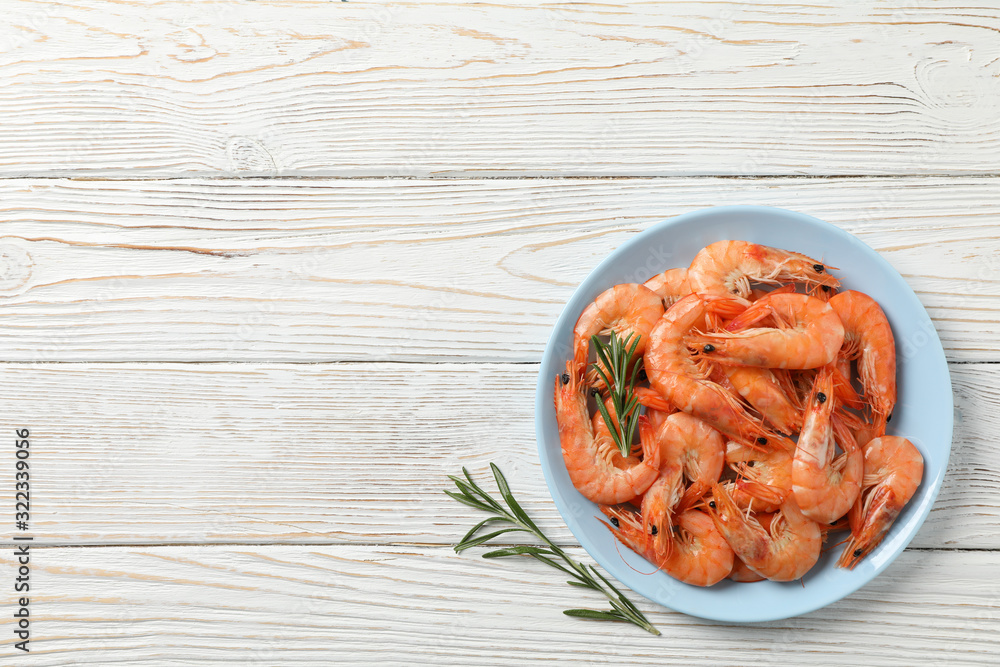 Plate with shrimps on wooden background, top view Plate with shrimps on wooden background, top view