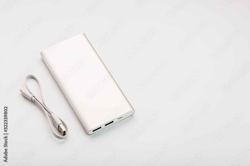 Powerbank for charging mobile devices with cable, on a white background. Powerbank for charging mobile devices with cable, on a white background.