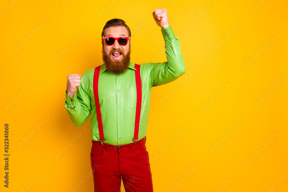 Portrait of ecstatic cheerful bearded lucky man raise fists win lottery scream yeah wear good looking outfit pants isolated over shine color background Portrait of ecstatic cheerful bearded lucky man raise fists win lottery scream yeah wear good looking outfit pants isolated over shine color background