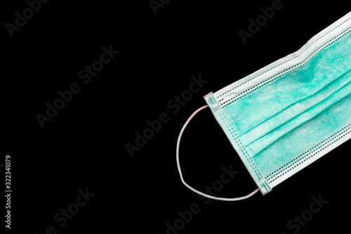 A green surgical mask for prevention of droplet transmittion on the black background photo