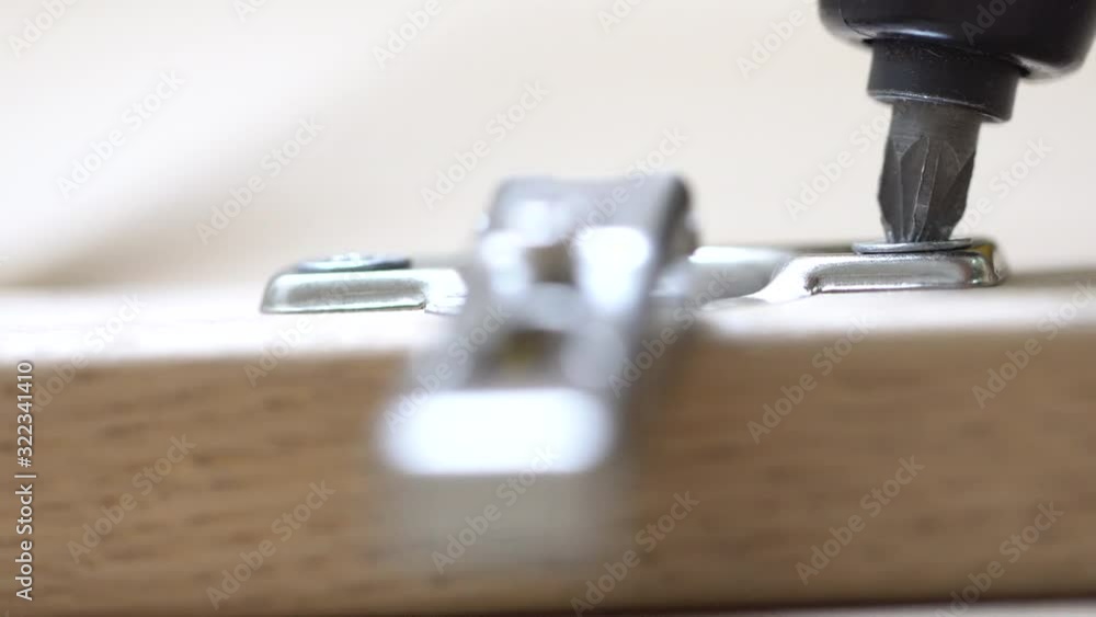 Electronic screwdriver is working on the furniture. Electronic screwdriver is working on the furniture.