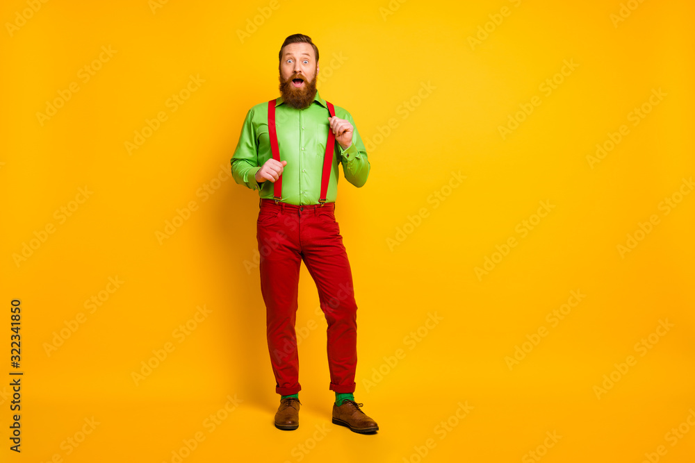 Full length photo of attractive funny guy model good mood excited news open mouth wear green shirt red suspenders pants socks footwear isolated bright color background Full length photo of attractive funny guy model good mood excited news open mouth wear green shirt red suspenders pants socks footwear isolated bright color background