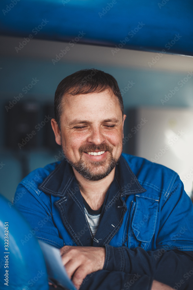 A bearded man of Caucasian appearance smiles a snow-white smile with his eyes closed. Happy and cheerful worker at the workplace A bearded man of Caucasian appearance smiles a snow-white smile with his eyes closed. Happy and cheerful worker at the workplace