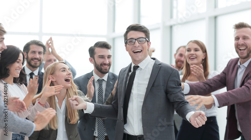 happy young businessman standing in front of his business team.