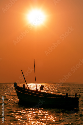 Silhouette of Small Wooden Boat Floating on the Sea © Teerasak