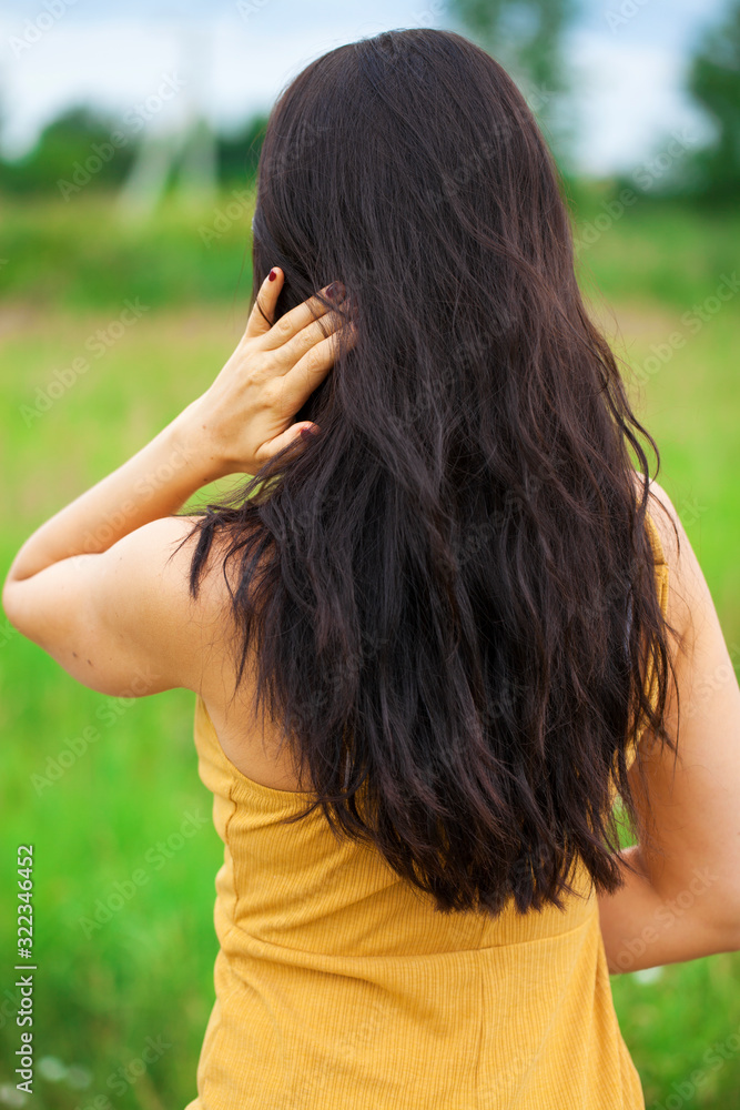 Female brunette hair, rear view, summer park Female brunette hair, rear view, summer park