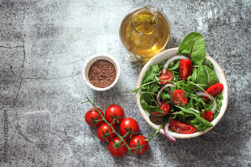 Fresh green mixed salad with cherry tomatoes in a wooden bowl