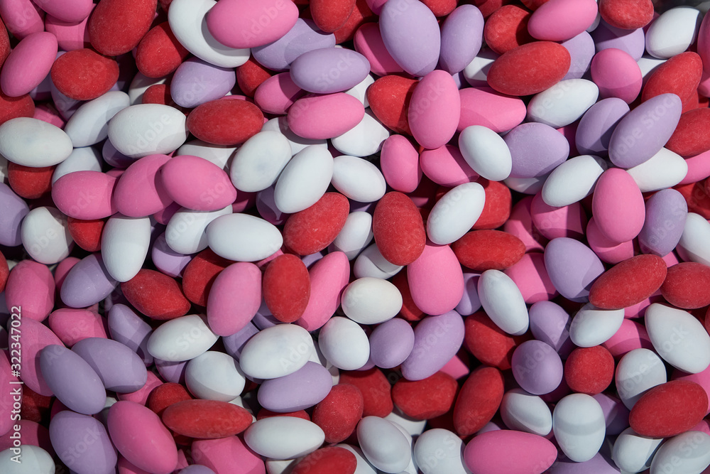 A bunch of colorful chocolate dragees. Almond covered with chocolate and multicolored glaze. Red pink and purple sweets. Candy shop. Candy background. A bunch of colorful chocolate dragees. Almond covered with chocolate and multicolored glaze. Red pink and purple sweets. Candy shop. Candy background.
