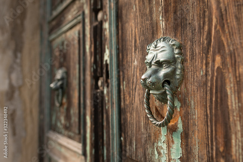 A bronze door handle on a wooden door in Venice