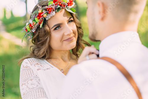 girl with a beautiful makeup and a wreath on the head fixes a bo