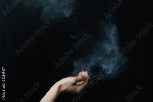 Smoke in hand. abstract fog. hand creates a magic spell