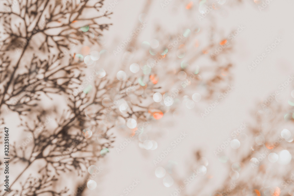 Naklejka premium Grey botanical shadows of branches on beige wall background with golden bokeh. Abstract background.
